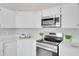 Bright kitchen featuring white cabinets, quartz countertops, and stainless steel appliances at 2262 Stonehedge Loop, Kissimmee, FL 34743