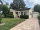Charming home featuring a quaint front yard and a detached garage with a brick paver driveway at 230 E Esther St, Orlando, FL 32806