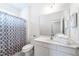 Bright bathroom featuring a shower with patterned curtain and a vanity with a large mirror and fresh white towels at 2613 Calistoga Ave, Kissimmee, FL 34741
