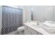 Well-lit bathroom featuring a white vanity, commode and shower/tub featuring a gray and white patterned shower curtain at 2613 Calistoga Ave, Kissimmee, FL 34741