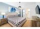 Comfortable bedroom with a queen-sized bed, patterned bedding, and a view into an en-suite bathroom at 2613 Calistoga Ave, Kissimmee, FL 34741