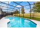 Sparkling pool with crystal-clear water, surrounded by a screened enclosure and a well-maintained yard at 2613 Calistoga Ave, Kissimmee, FL 34741