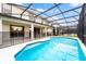 Enclosed pool area featuring blue tiled pool, screened enclosure and furniture for relaxing in the sun at 2613 Calistoga Ave, Kissimmee, FL 34741