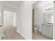 Hallway view of a bathroom with modern toilet, tub, and vanity at 7500 Toscana Blvd # 331, Orlando, FL 32819