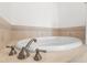 Close up on an elegant tiled bathtub with modern fixtures and ample space for relaxation at 7500 Toscana Blvd # 331, Orlando, FL 32819