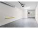 Clean one car garage with neutral colored block walls, a door into the unit, and a gray sealed floor at 7500 Toscana Blvd # 331, Orlando, FL 32819