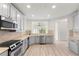 Well-lit kitchen featuring stainless steel appliances, wood-look flooring, and white cabinets at 7500 Toscana Blvd # 331, Orlando, FL 32819