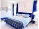 Cozy bedroom with bright blue accents, including bed frame and curtains, and plenty of natural light at 7858 Spectrum Dr, Reunion, FL 34747
