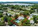 Aerial view of home showcasing lush surroundings, pool, and proximity to a serene lake at 904 15Th Ne St, Winter Haven, FL 33881