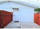 Back exterior view with a white door and dark brown fence at 904 15Th Ne St, Winter Haven, FL 33881