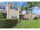 Back exterior with palm trees, a screened lanai, and lush green lawn and landscaping at 1011 Wood Cv, Kissimmee, FL 34743