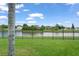 Backyard with a view of the pond, black aluminum fence, and lush landscaping at 1011 Wood Cv, Kissimmee, FL 34743