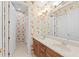 Bathroom featuring double sinks, a walk-in shower, and floral wallpaper at 1011 Wood Cv, Kissimmee, FL 34743