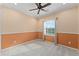 Neutral bedroom with a carpeted floor, single window, and chair railing at 1011 Wood Cv, Kissimmee, FL 34743