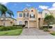 Beautiful front exterior of a two-story home with a brick driveway, stone accents, and mature landscaping at 1011 Wood Cv, Kissimmee, FL 34743