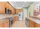 Modern kitchen with stainless appliances, granite counters, and ample cabinet space at 1011 Wood Cv, Kissimmee, FL 34743