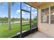 Screened patio showcasing a serene view of the lush green lawn, pond and palm tree at 1011 Wood Cv, Kissimmee, FL 34743
