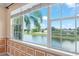 View from a window overlooking a scenic pond with palm trees, blue sky, and well-manicured landscaping at 1011 Wood Cv, Kissimmee, FL 34743