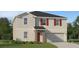 Charming two-story home with gray siding, red shutters, stone accents, and a well-manicured lawn at 3684 Rolling Ridge Bnd, Davenport, FL 33837