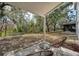 Expansive backyard view from the covered patio with two chairs, showing beautiful greenery and trees at 14217 Sapphire Bay Cir, Orlando, FL 32828