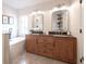 Luxurious bathroom with double vanity, soaking tub, and elegant mirrors for a spa-like retreat at 14217 Sapphire Bay Cir, Orlando, FL 32828