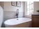 Luxurious freestanding bathtub with a modern faucet, set against a backdrop of neutral-toned tiles at 14217 Sapphire Bay Cir, Orlando, FL 32828
