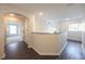Upstairs hallway featuring a hardwood floor and a view into an adjacent bedroom with an arched window at 14217 Sapphire Bay Cir, Orlando, FL 32828