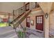 A welcoming apartment exterior featuring red doors, brick accents, and stairwell to the second level at 200 St Andrews Blvd # 802, Winter Park, FL 32792