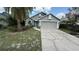 Charming single-Gathering home featuring a well-manicured lawn and a two-car garage at 324 River Chase Dr, Orlando, FL 32807