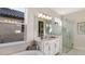 Bright bathroom features a double vanity, a large mirror, and a glass-enclosed shower for a luxurious feel at 858 Arbor Green Trl, St Cloud, FL 34771