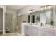 Bright bathroom with double vanity, granite counters, and glass enclosed shower at 858 Arbor Green Trl, St Cloud, FL 34771