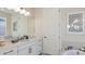 Bright bathroom features a white vanity with bronze hardware, a large mirror, and a soaking tub at 858 Arbor Green Trl, St Cloud, FL 34771