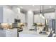 Modern kitchen features white cabinets, stainless steel appliances, a center island, and pendant lighting at 858 Arbor Green Trl, St Cloud, FL 34771