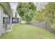Spacious backyard featuring a screened-in porch, lush green lawn, and mature trees providing ample shade at 643 Oregon Woods Ct, Orlando, FL 32824