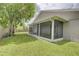 Spacious backyard with lush green grass, large tree, and a screened-in patio for outdoor enjoyment at 643 Oregon Woods Ct, Orlando, FL 32824