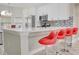 Modern kitchen with white cabinetry, stainless steel appliances, and a breakfast bar with red seating at 643 Oregon Woods Ct, Orlando, FL 32824
