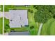 Aerial view of a home with a well-maintained lawn, mature trees, and an enclosed lanai at 785 Hawks Bluff, Clermont, FL 34711
