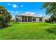 Spacious backyard with lush green grass, a screened-in porch, and mature trees at 785 Hawks Bluff, Clermont, FL 34711