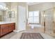 Open bathroom layout with glass shower, soaking tub, wood vanity, and tile flooring at 785 Hawks Bluff, Clermont, FL 34711