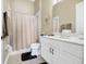 Bright bathroom features a shower with curtain, toilet, and white vanity with ample counter space at 785 Hawks Bluff, Clermont, FL 34711