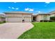 A well-maintained house with a brick driveway and a manicured lawn at 785 Hawks Bluff, Clermont, FL 34711