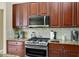 Kitchen with stainless steel range and microwave, granite countertops, and ample storage at 785 Hawks Bluff, Clermont, FL 34711