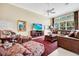 Spacious living room with a ceiling fan, large windows, and cozy seating arrangement at 785 Hawks Bluff, Clermont, FL 34711