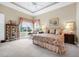 Elegant main bedroom features a tray ceiling, neutral walls, floral bedding, and decorative furniture at 785 Hawks Bluff, Clermont, FL 34711