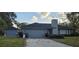 Charming single story home featuring an attached two-car garage and lush green lawn at 1405 Ridgegreen N Loop, Lakeland, FL 33809