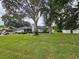Lovely single-story home with mature trees, lush green lawn, and an attached two-car garage at 1405 Ridgegreen N Loop, Lakeland, FL 33809