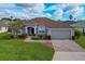 Charming single-story home with manicured lawn, brick driveway, and attached two-car garage at 344 Barbera Dr, Davenport, FL 33897