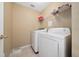 Laundry room featuring a white washer and dryer, tile flooring and wire shelving at 344 Barbera Dr, Davenport, FL 33897