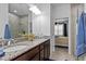 Bright bathroom with double sinks, granite countertops, glass shower, and bedroom view at 311 Pop Top Ln, Daytona Beach, FL 32124