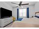 Modern bedroom featuring a large TV, ceiling fan, and natural light at 311 Pop Top Ln, Daytona Beach, FL 32124